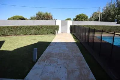 a garden with a fence and a swimming pool at Villa dos Salgados - Beachfront, 6 Golf Courses, 6BDR in Guia
