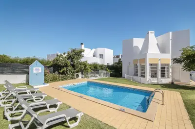 a swimming pool with lounge chairs next to a building at Villa Santo Estevão in Olhos de Água
