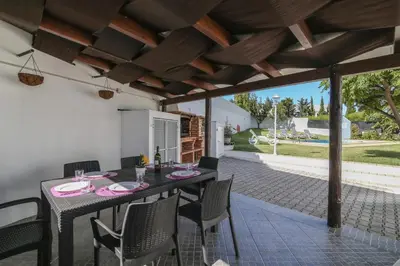 a dining room with a table and chairs on a patio at Villa Santo Estevão in Olhos de Água