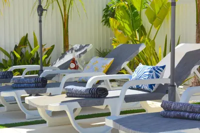 a row of blue and white lounge chairs with pillows at VILA CRISTINA MAR (8 guests and oceanview) in Albufeira