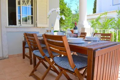 a wooden table and chairs on a patio at VILA CRISTINA MAR (8 guests and oceanview) in Albufeira