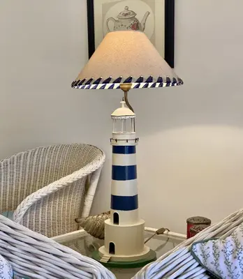 a lighthouse lamp on a table next to a chair at Marina Mar - Near the beach - Vilamoura in Vilamoura