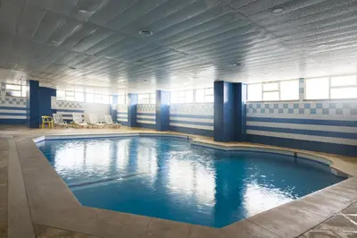 a large swimming pool with blue water in a building at Marina Mar - Near the beach - Vilamoura in Vilamoura