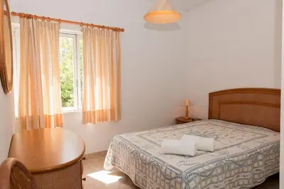 a bedroom with a bed and a table and a window at TAC - Vilamoura Center in Vilamoura