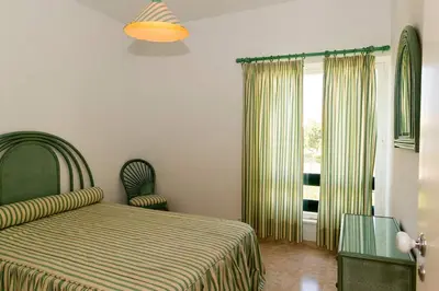 a bedroom with a bed and a window with curtains at TAC - Vilamoura Center in Vilamoura