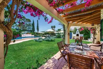 a patio with a table and chairs under a pergola at Villa Hideaway by Algarve Villa Holidays in Galé