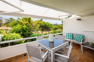 a patio with a table and chairs on a balcony at Victory Village T1 & Rooftop terrace in Quinta do Lago