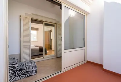 a room with a sliding glass door with a zebra chair at Villa Cantinho by Intiholidays in Albufeira