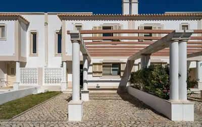 a white building with a wooden staircase in front of it at Villa Cantinho by Intiholidays in Albufeira