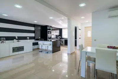 a kitchen with white cabinets and a table and chairs at Villa Cantinho by Intiholidays in Albufeira