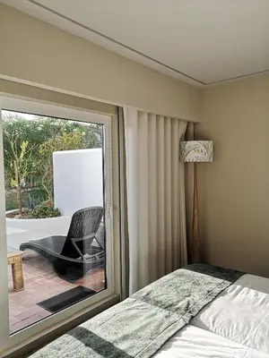 a bedroom with a bed and a window with a chair at Victory Village 16F in Quinta do Lago