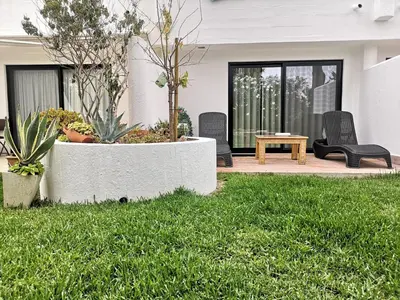 a patio with chairs and a table in the grass at Victory Village 16F in Quinta do Lago