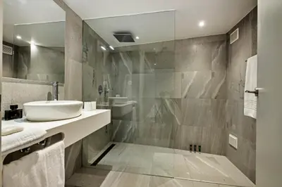 a bathroom with a sink and a shower at Forte São João Villas da Praia in Albufeira
