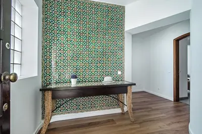 a room with a table with a green and white wall at Forte São João Villas da Praia in Albufeira