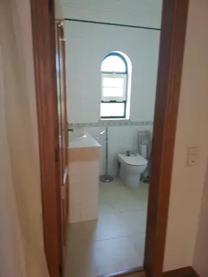 a bathroom with a toilet and a sink and a mirror at Villa V2 AA in Olhos de Água
