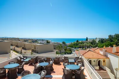 a balcony with tables and chairs and a view of the ocean at Bellavista Jardim By BeGuest in Albufeira
