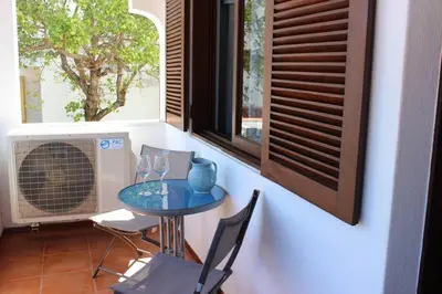 a room with a table and chairs and a window at A dois passos da praia in Albufeira