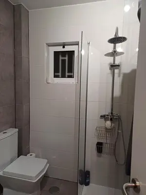 a bathroom with a toilet and a glass shower at A dois passos da praia in Albufeira