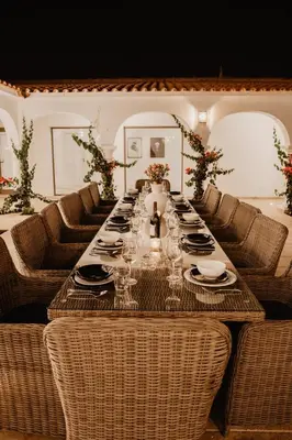 a long table with chairs and plates and wine glasses at Granvila in Quarteira