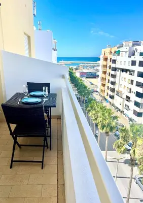 a table and chairs on a balcony with a view of the ocean at Apartamento Millenium Vista Mar- 2 passos da Praia in Quarteira