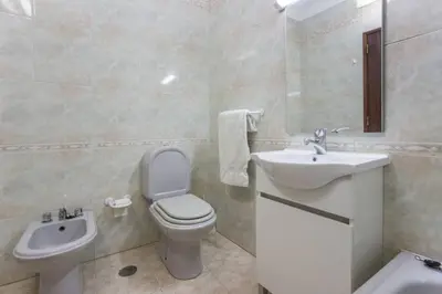 a bathroom with a toilet and a sink at Apartamento Millenium Vista Mar- 2 passos da Praia in Quarteira