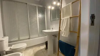 a white bathroom with a sink and a toilet at Lusitania T2 Frente Mar em Quarteira in Quarteira
