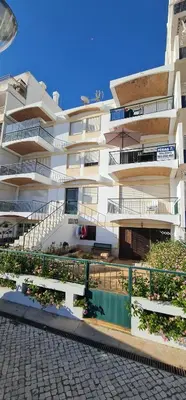 a large apartment building with balconies and a courtyard at Lusitania T2 Frente Mar em Quarteira in Quarteira