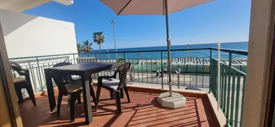 a balcony with a table and a view of the ocean at Lusitania T2 Frente Mar em Quarteira in Quarteira