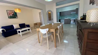 a kitchen and living room with a table and a couch at Lusitania T2 Frente Mar em Quarteira in Quarteira