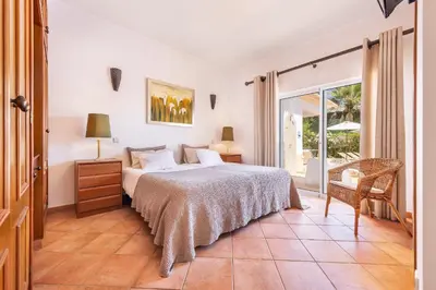 a bedroom with a bed and a sliding glass door at Villa Ericeira by OCvillas in Albufeira