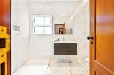 a white bathroom with a sink and a mirror at Villa Ericeira by OCvillas in Albufeira