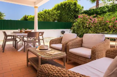 a patio with wicker chairs and a table and a tableablish at Villa Ericeira by OCvillas in Albufeira