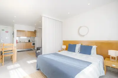 a bedroom with a large bed and a kitchen at Bay View by OCvillas in Albufeira