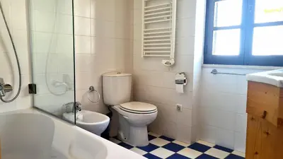 a bathroom with a toilet and a tub and a sink at Albufeira Beach Cliffs House in Albufeira
