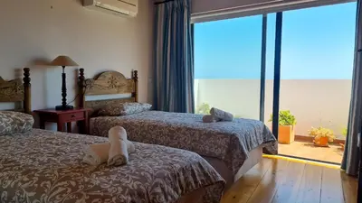 a hotel room with two beds and a large window at Albufeira Beach Cliffs House in Albufeira