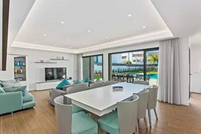 a living room with a white table and chairs at Villa Ohana in Albufeira