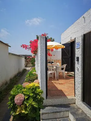 a patio with a table and an umbrella at Vila Planalto - Golfe - Entre o Golfe e o Mar in Vilamoura