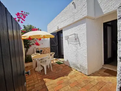 a patio with an umbrella and a table and chairs at Vila Planalto - Golfe - Entre o Golfe e o Mar in Vilamoura