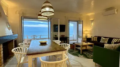a living room with a table and chairs and the ocean at Beira Mar by Check-in Portugal in Albufeira