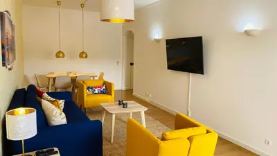 a living room with a blue couch and yellow chairs at Rooftop by Check-in Portugal in Albufeira