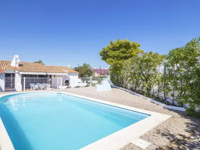 a swimming pool in the yard of a house at Villa Villa Jacaranda V3 by Interhome in Albufeira