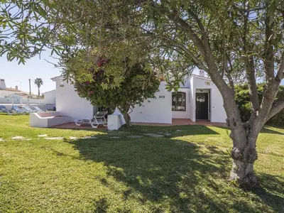 a white house with a tree in the yard at Villa Villa Jacaranda V3 by Interhome in Albufeira