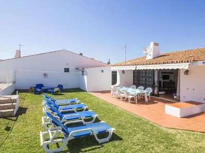 a group of blue lounge chairs on a yard at Villa Villa Jacaranda V3 by Interhome in Albufeira