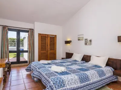 a bedroom with a blue and white bed and a window at Villa Villa Jacaranda V3 by Interhome in Albufeira