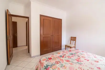 a bedroom with a bed and a wooden door at Marjoh Al in Quarteira