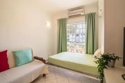 a bedroom with a bed with green curtains and a window at Marjoh Al in Quarteira
