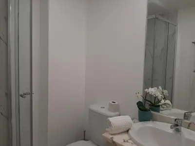 a bathroom with a sink and a toilet and a mirror at Quarteira SeaSide in Quarteira