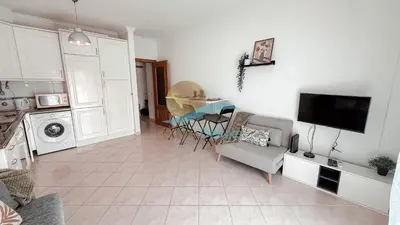 a living room with a tv and a table and chairs at Kamaleon Sol by Sunny Deluxe in Albufeira