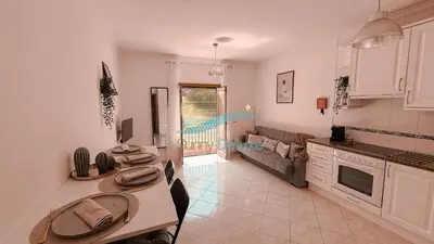 a kitchen and living room with a table and a couch at Kamaleon Sol by Sunny Deluxe in Albufeira