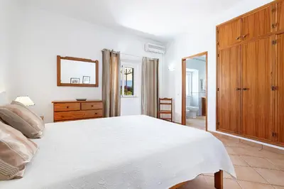 a bedroom with a white bed and a mirror at Casa da Bia by OCvillas in Albufeira